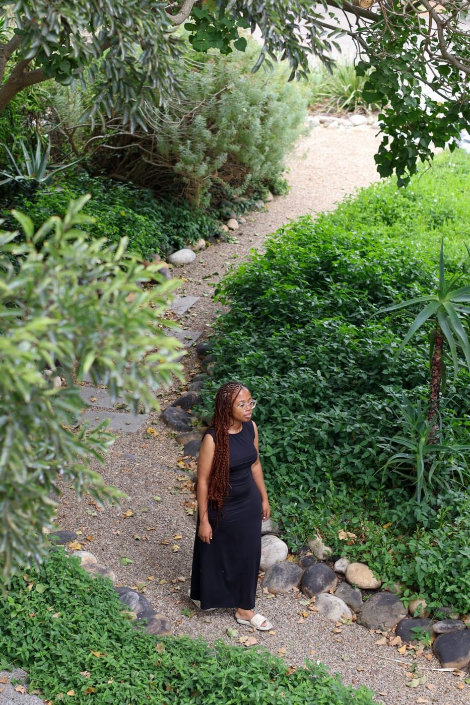 Okuhle walking along a gravel garden path between aloes and shrubs